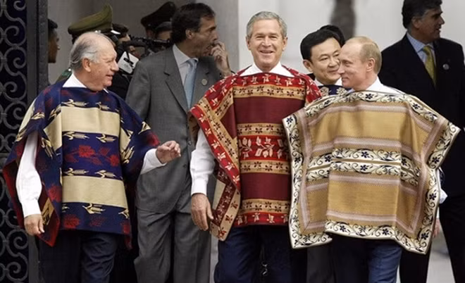Bức ảnh này được chụp tại kỳ APEC 2004 ở Santiago, Chile. Các lãnh đạo diện chiếc khăn chamanto theo phong cách truyền thống của Chile. Chamanto được dệt từ lụa và len, có thể sử dụng được cả hai mặt. Ảnh: Reuters
