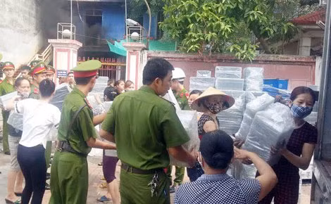 Những chiến sĩ Công an cùng với công nhân vận chuyển tài sản ra nơi an toàn