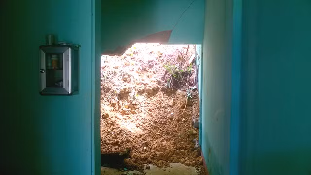 Một nhà dân bị đất đổ sập bên hông nhà.
