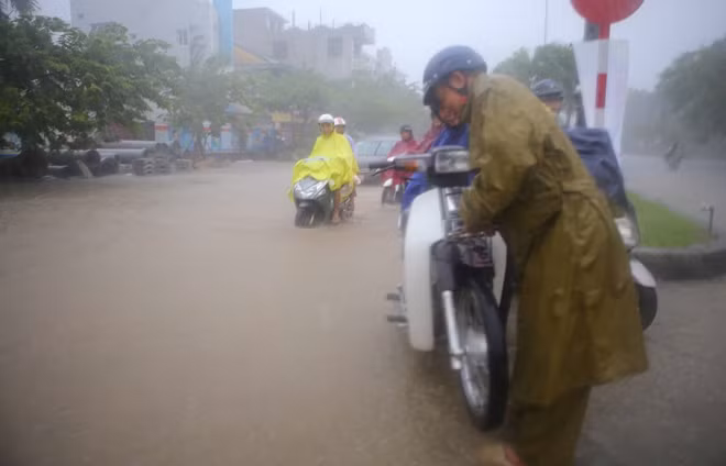 Vất vả khi xe máy bị chết máy trên tuyến đường ngập nặng như thế này.