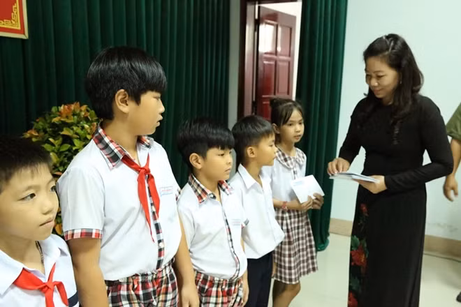 Bà Đỗ Thị Hồng tặng quà cho các em học sinh.