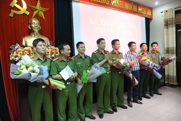 Đại tá Nguyễn Mạnh Hùng, Phó Giám đốc, thủ trưởng CQCSĐT Công an tỉnh Nghệ An tặng hoa chúc mừng và thưởng cho Ban chuyên án.