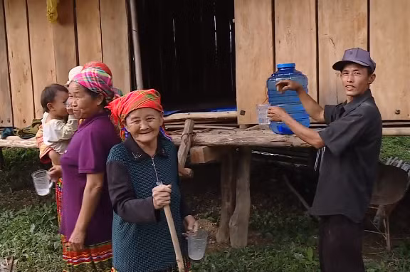 Bà con quây quần bên căn nhà của Thào Chư Lèo để uống nước sạch.
