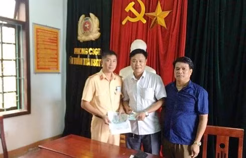 Thiếu tá Vinh trao trả ví tiền cho anh Sơn.