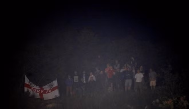 Dù án phạt dành cho CĐV Croatia nhưng vô tình, những người hâm mộ bóng đá Anh cũng bị vạ lây bởi quyết định này. Tuy vậy, theo ước tính, vẫn có khoảng 500 CĐV ĐT Anh tới SVĐ HNK Rijeka để cổ vũ đội nhà . Tất nhiên, họ không vào sân mà sẽ dự khán trận đấu trên một khán đài đặc biệt. Trong ảnh một nhóm CĐV Anh đứng ngoài sân cố gắng cổ vũ Tam Sư.