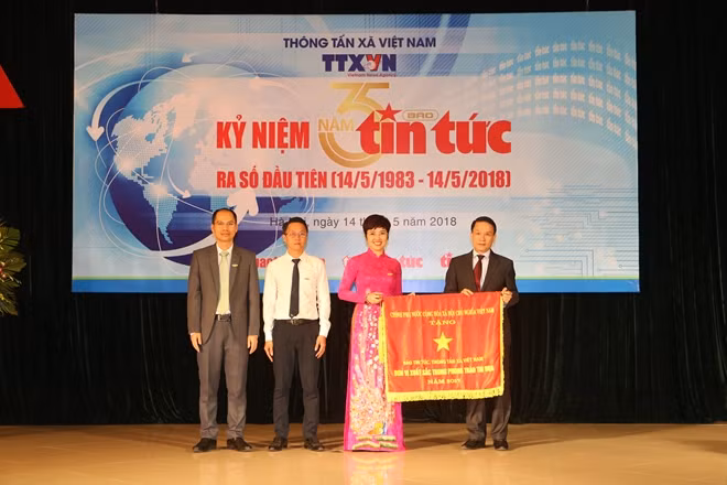 Thừa ủy quyền của Thủ tướng Chính phủ, Tổng giám đốc Thông tấn xã Việt Nam Nguyễn Đức Lợi trao Cờ Thi đua của Chính phủ cho Báo Tin tức
