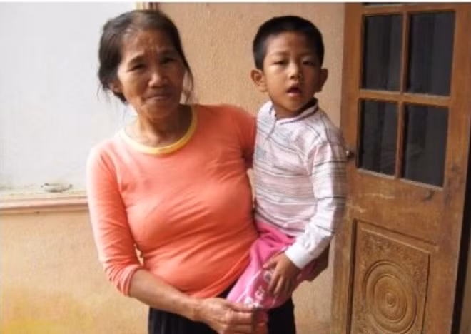 Bà Nguyễn Thị Khoa - mẹ chồng Cao Thị Bình và đứa cháu bị bại não.