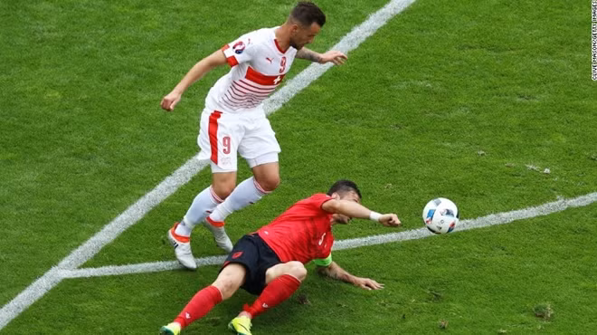 Đội trưởng Lorik Cana (áo đỏ) của Albania nhận thẻ vàng thứ 2 rời sân sau pha chơi bóng bằng tay