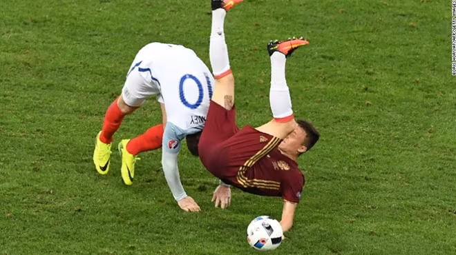 Tiền đạo người Anh Wayne Rooney (áo trắng) trong pha va chạm với tiền vệ người Nga Aleksandr Golovin