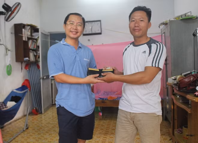 Anh Lê Văn Hiếu (bên phải) trả lại tài sản cho anh Nguyễn Thành Tâm.