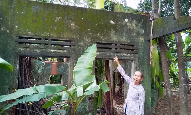 Bà Lợi bên căn nhà của gia đình bỏ hoang sau trận "đại hồng thủy" năm 1999.