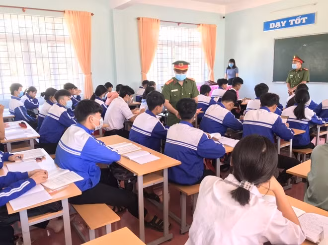 Cán bộ Công an huyện Đắk R’lấp phát tờ rơi tuyên truyền pháp luật tại Trường THPT Nguyễn Đình Chiểu.