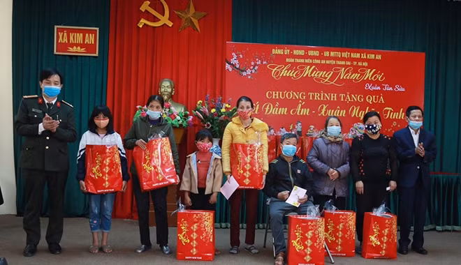 Thượng tá Nguyễn Văn Tiệp (ngoài cùng bên trái), Phó trưởng CAH Thanh Oai và ông Trần Văn Phấn(ngoài cùng bên phải), Bí thư Đảng ủy, Chủ tịch HĐND xã tặng quà các gia đình