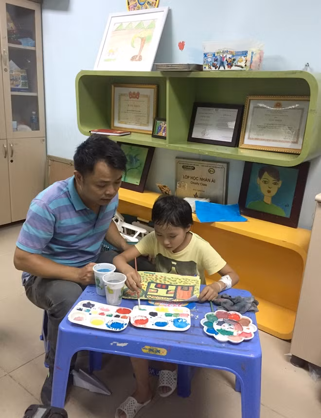 Họa sỹ Nguyễn Tuấn Sơn bên học trò nhí Hạng Thị Do.