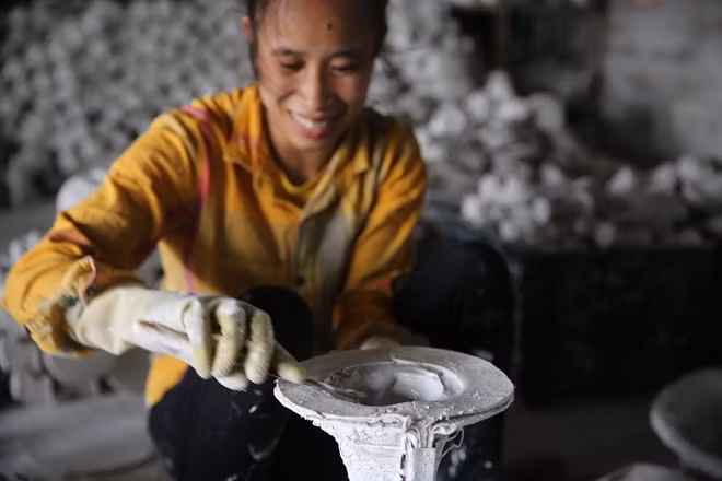 Một người thợ bắt đầu đổ khuôn.