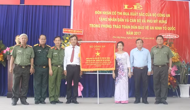 Nhân dân và cán bộ xã Phú Mỹ Hưng nhận Cờ Thi đua xuất sắc trong phong trào Toàn dân bảo vệ ANTQ năm 2017 của Bộ trưởng Bộ Công an.
