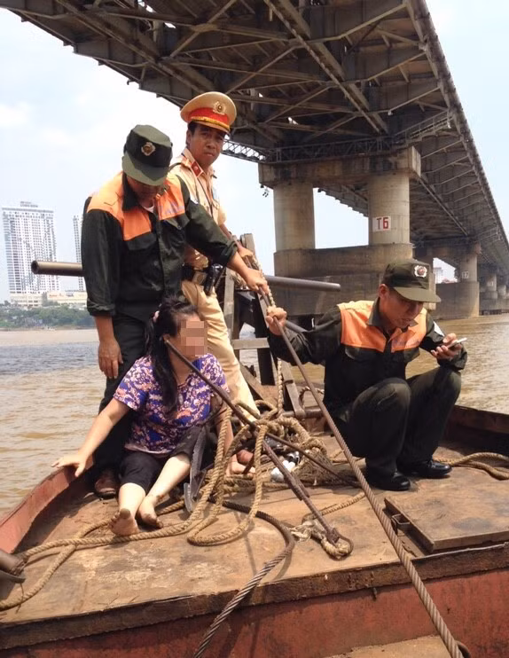 Người phụ nữ 40 tuổi may mắn được CSGT và bảo vệ cầu cứu sống. Ảnh: Hoàng Lam.