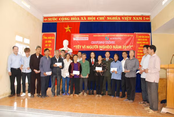 Đại tá Trần Thanh Phong, Trưởng ban Phát triển – Bạn đọc, đại diện Agribank, Công an tỉnh Yên Bái trao quà Tết tới đồng bào nghèo xã Châu Quế Hạ.