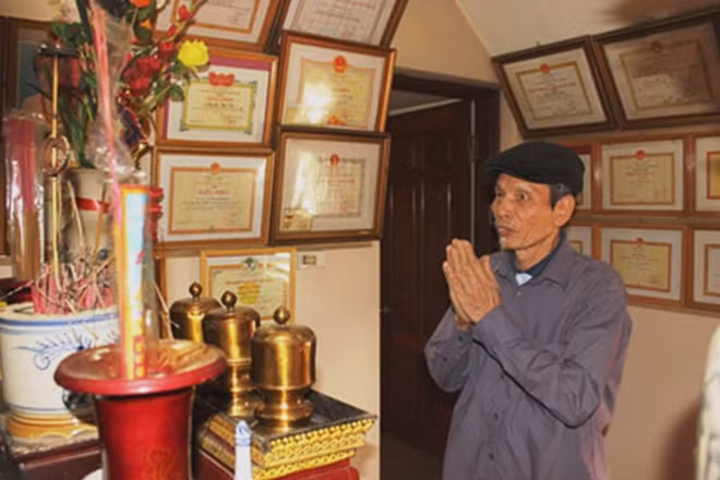 Ông Nguyễn Văn Giáo trước bàn thờ gia tiên.