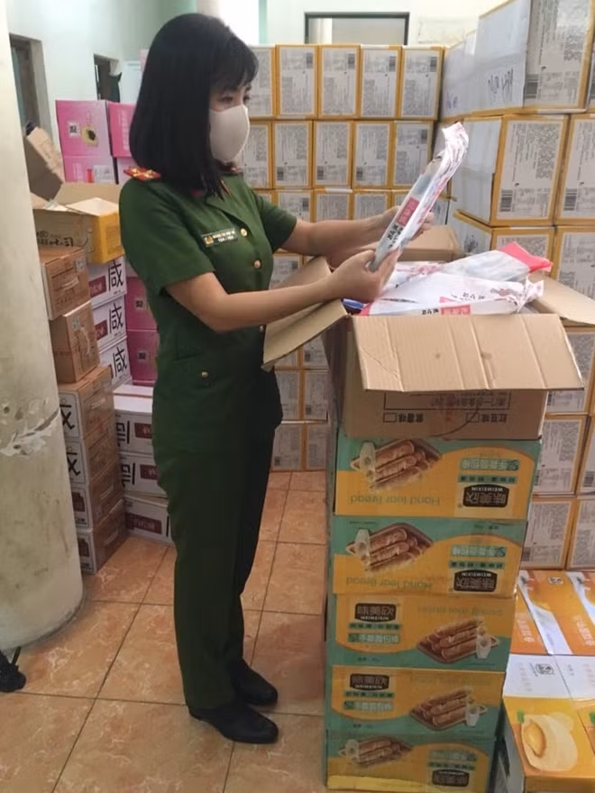 Đại úy Hoàng Thị Việt Hà kiểm tra bánh, kẹo không rõ nguồn gốc.
