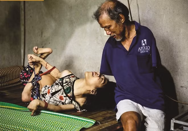 Ông Hoa Xuân Tứ chăm sóc người con tật nguyền.