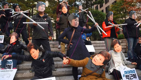 Những người biểu tình đeo mặt nạ Tổng thống Park Geun-hye và bà Choi Soon-sil. Ảnh: CNN