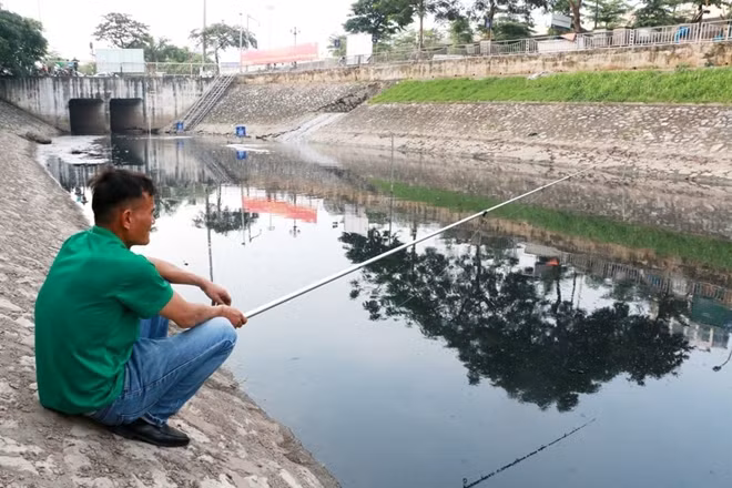 Anh Tình - một người dân sống gần đoạn sông này giờ còn ra đây câu cá..