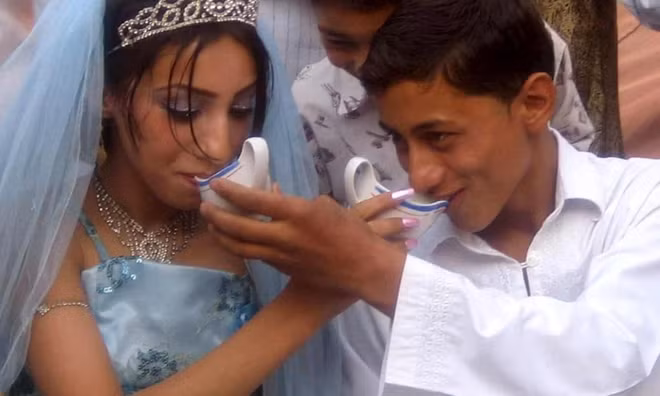 Một cặp vợ chồng trẻ người Afghanistan uống nước ngọt truyền thống trong lễ cưới ở Herat, Afghanistan.