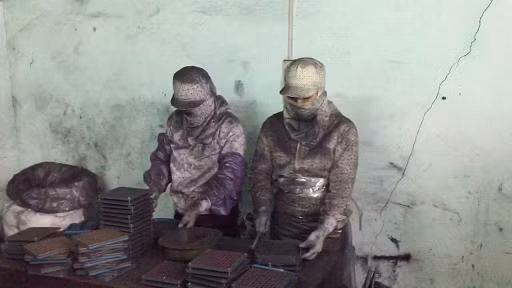 Công nhân đang ép bột than tre đã tán mịn vào các vỏ thuốc con nhộng, đóng gói bán cho bệnh nhân ung thư.