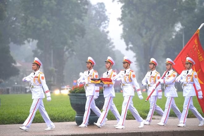 Nghi lễ treo băng tang được tiến hành song song với nghi thức chào cờ thường ngày vẫn diễn ra trên quảng trường Ba Đình.