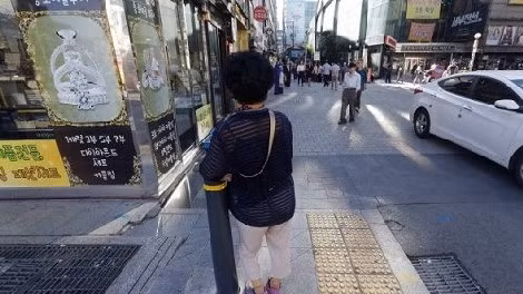 Một phụ nữ già trước rạp Piccadilly ở Seoul, nơi các gái bán dâm cao tuổi chào mời khách.