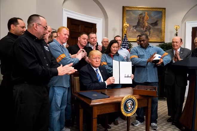 Tổng thống Mỹ Donald Trump ký sắc lệnh áp thuế mới với nhôm và thép ngày 8-3 bên cạnh những công nhân của hai ngành công nghiệp này. Ảnh: New York Times.