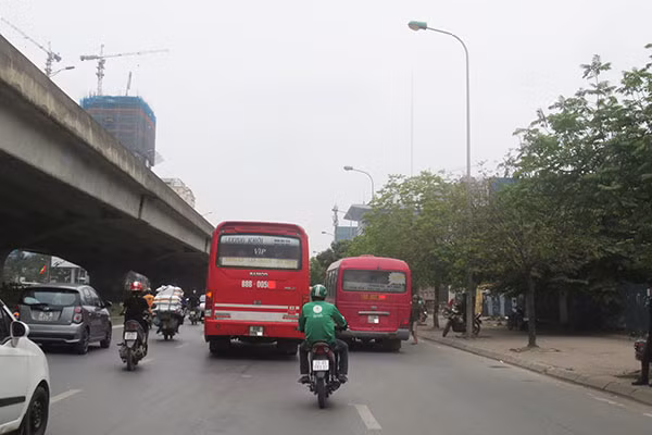 Xe khách đi dàn hàng ngang để “vợt” khách trên đường Phạm Hùng.