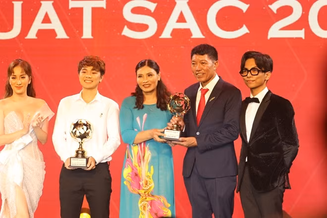 Bố mẹ Đoàn Văn Hậu lên nhận thay con trai giải thưởng cầu thủ trẻ nam xuất sắc nhất. Ảnh: CTV.