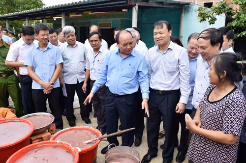 Thủ tướng thăm một gia đình làm nghề chế biến thủy sản trong xã Đức Trạch. Ảnh: VGP/Nhật Bắc