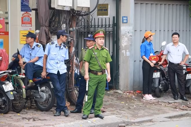 Trong ảnh lực lượng Công an túc trực bên ngoài Trường THPT Thăng Long(Hà Nội) trong sáng 25-6.