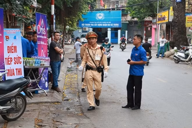 Ngoài ra, Công an các quận, huyện tại Hà Nội đã thành lập các tổ công tác tiến hành kiểm tra các cơ sở kinh doanh in ấn, photocopy trước và trong các ngày thi nhằm phát hiện, ngăn chặn các trường hợp photocopy đề thi, bán đáp án bài thi để đưa vào phòng thi... Trong ảnh: Lực lượng CSGT Hà Nội đảm bảo trật tự bên ngoài một địa điểm thi THPT quốc gia.