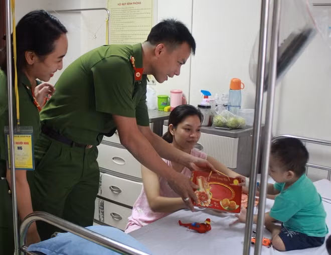 Cán bộ chiến sĩ Học viện CSND và các nhà hảo tâm trao quà, động viên các bệnh nhi.