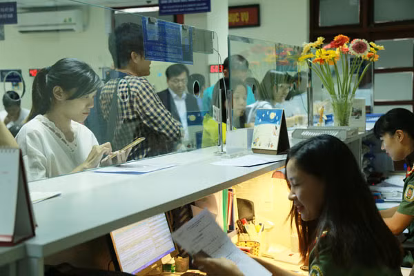 Cán bộ Cục Quản lý xuất nhập cảnh hướng dẫn làm thủ tục cho người dân.