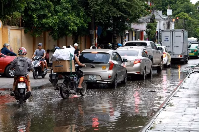 Càng về cuối giờ chiều thì lượng phương tiện qua đây càng đông. Mỗi khi có đèn đỏ hàng loạt xe phải dừng lại trong dòng nước bẩn....