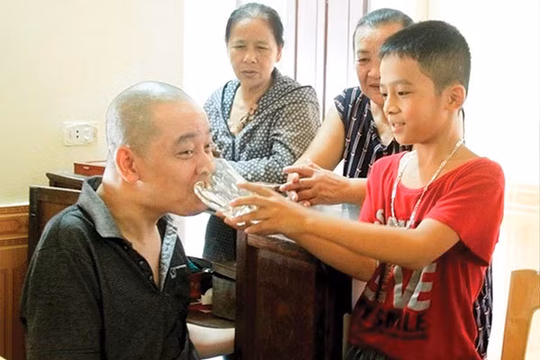 Sau giờ học, cu Hoàn lại thay mẹ chăm sóc bố trong sinh hoạt thường ngày.