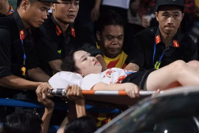 Nữ CĐV được đưa xuống khỏi khán đài bằng cáng.