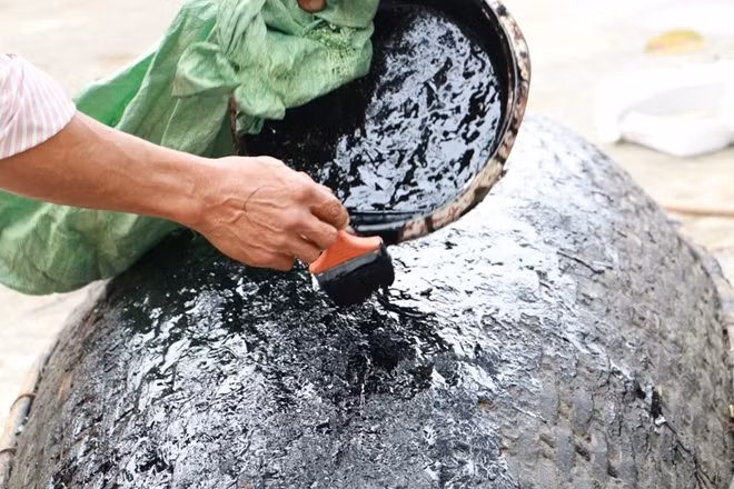 Sau khi làm xong một chiếc thuyền người quét một lớp hắc in lên đáy thuyền.