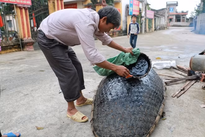 Sau khi làm xong một chiếc thuyền người quét một lớp hắc in lên đáy thuyền.