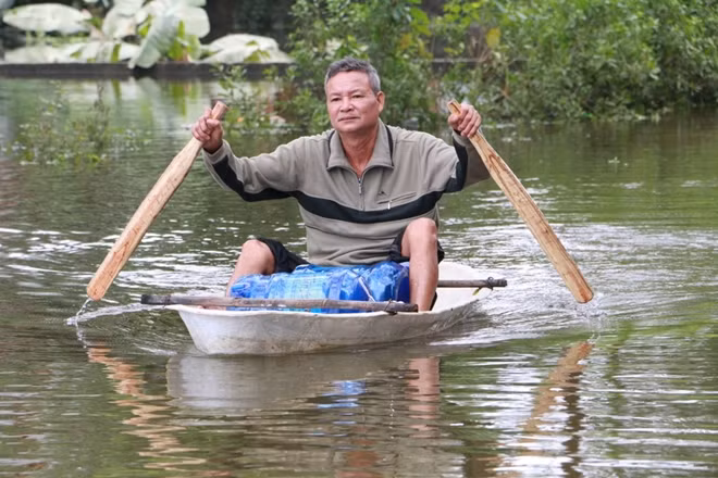 Bên cạnh thuyền nan truyền thống, các loại thuyền tự chế khác cũng xuất hiện nhiều tại huyện Chương Mỹ trong thời gian này. Trong ảnh là một người dân xã Tân Tiến đang dùng thuyền nhựa chở nước uống về nhà.