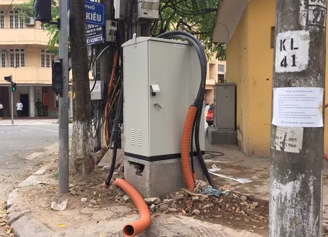 Gạch vỡ, dây cáp bao quanh một trụ điện.