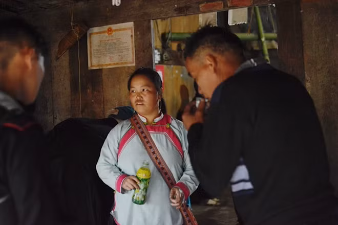 Một người phụ nữ đang đi mời rượu, người này mời người kia họ uống đến khi say thì thôi.