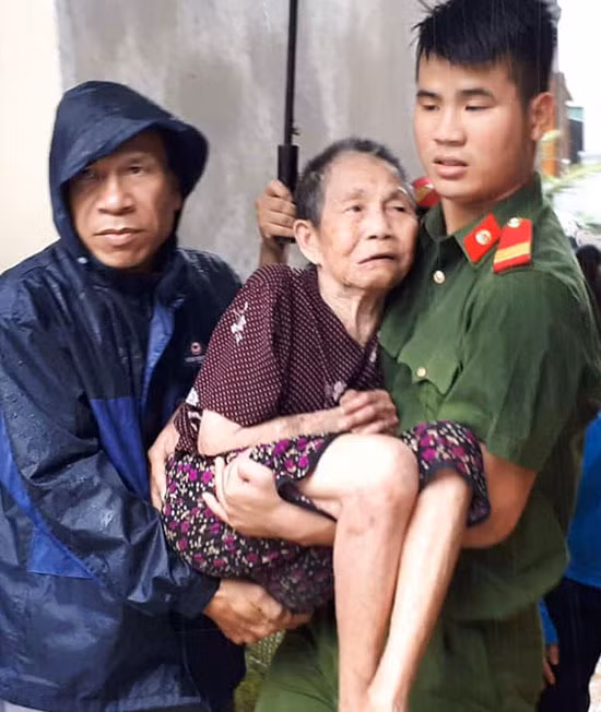 Lực lượng công an và quân đội được huy động giúp người già, trẻ em ở huyện Con Cuông di chuyển đến nơi an toàn. Ảnh: Bá Hậu.