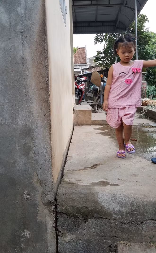 Khoảnh sân hẹp đã nứt, tách khỏi nhà của gia đình chị Hồng.