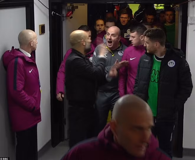 HLV Pep Guardiola to tiếng với đồng nghiệp trong đường hầm sân vận động. Ảnh: BBC.